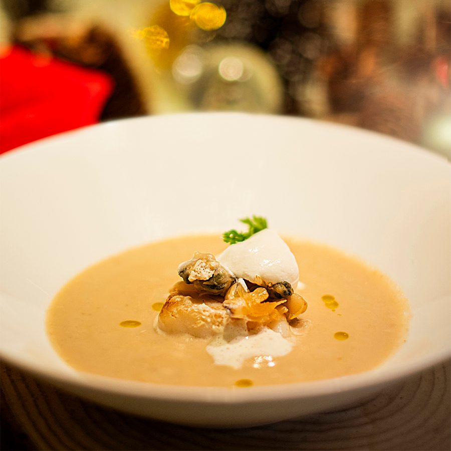 Close-up of a chestnut soup with scallops and clams. 